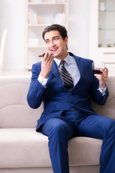 Empresario bebiendo vino sentado en casa — Foto de Stock