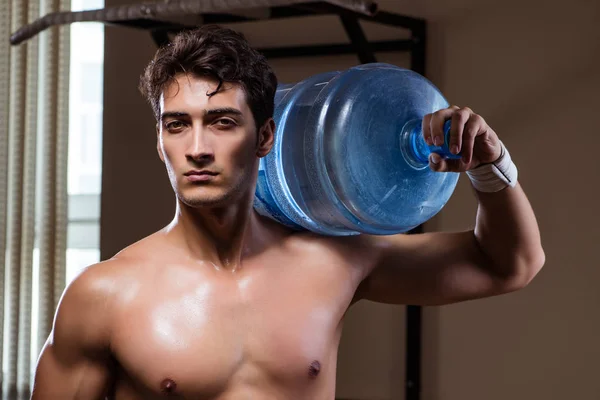 Uomo strappato muscolare con grande bottiglia d'acqua — Foto Stock