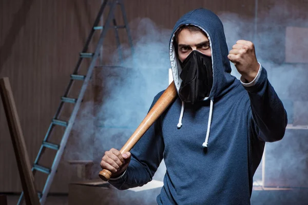 Hooligan with bat in dark room — Stock Photo, Image