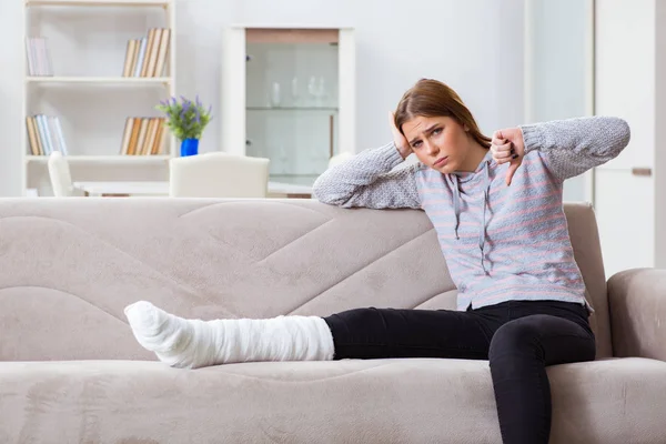Νεαρή γυναίκα με σπασμένο πόδι στο σπίτι — Φωτογραφία Αρχείου