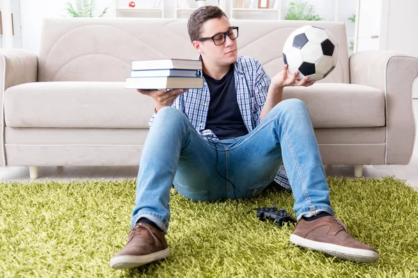 Молодой студент пытается сбалансировать учебу и игру в футбол — стоковое фото