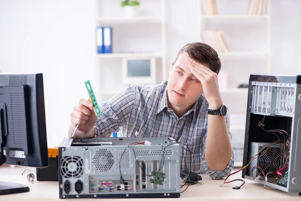 Young technician repairing computer in workshop — Stock Photo, Image