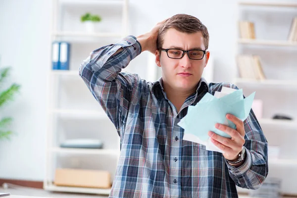 Mladý muž frustrovaný z jeho domu a daňových účtů — Stock fotografie