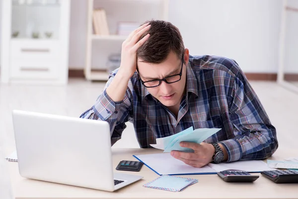 Junger Mann frustriert über sein Haus und Steuerrechnungen — Stockfoto