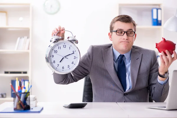 Empregado com piggybank no conceito de gerenciamento de tempo — Fotografia de Stock