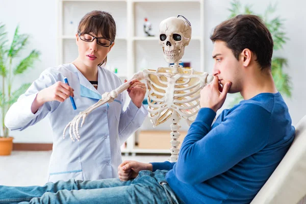 Läkare som visar typ av skada på skelett till patienten — Stockfoto