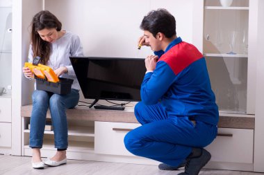 TV tamircisi evde televizyon tamir ediyor.