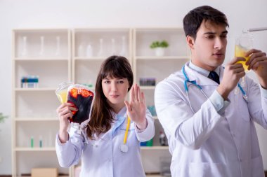 İki doktor plazma ve kan naklini tartışıyor.