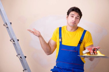 Duvara alçı yapıştıran genç müteahhit.