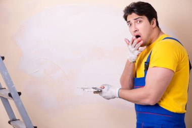 Duvara alçı yapıştıran genç müteahhit.