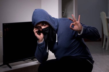 Hırsız, apartmandan televizyon çalıyor.