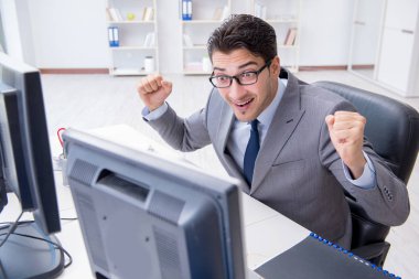 Genç işadamı masasında çalışıyor.