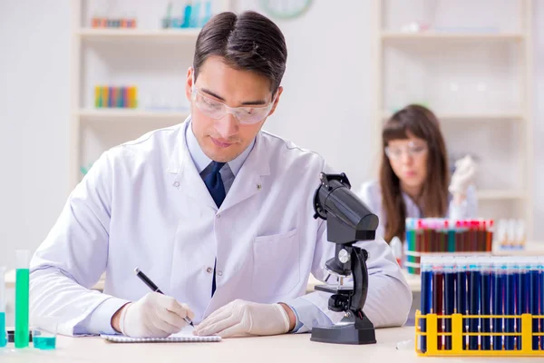 Two chemists working in lab experimenting — Stock Photo, Image