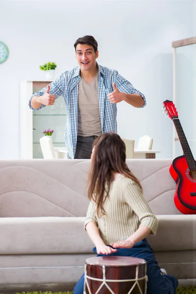 Young family singing and playing music at home