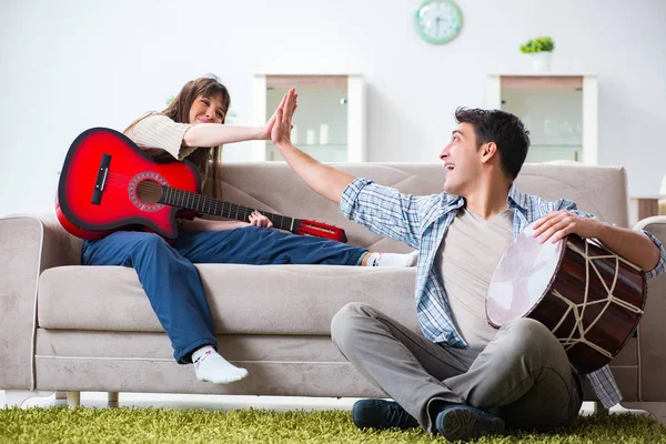 Mladá rodina zpívá a hraje doma hudbu — Stock fotografie