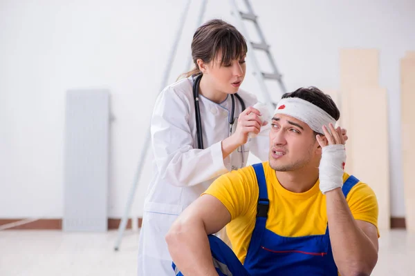 Lavoratore con testa ferita e medico — Foto Stock