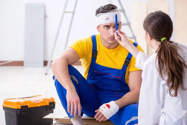 Lavoratore con testa ferita e medico — Foto Stock