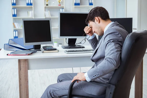 Geschäftsmann sitzt vor vielen Bildschirmen — Stockfoto