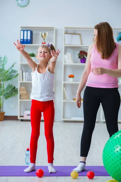 Menina e mãe se exercitando em casa — Fotografia de Stock