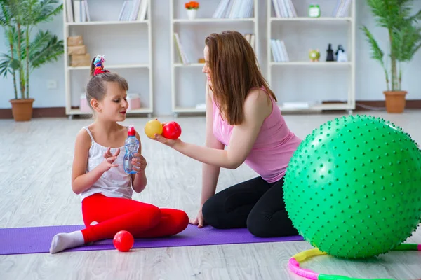 Ragazza e madre che si esercitano a casa — Foto Stock