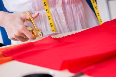 Yeni elbise tasarımları üzerinde çalışan kadın terzi.