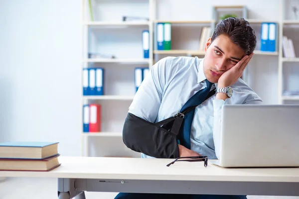 Biznesmen ze złamaną ręką pracujący w biurze — Zdjęcie stockowe