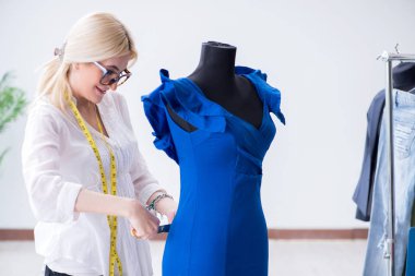 Yeni elbise tasarımları üzerinde çalışan kadın terzi.
