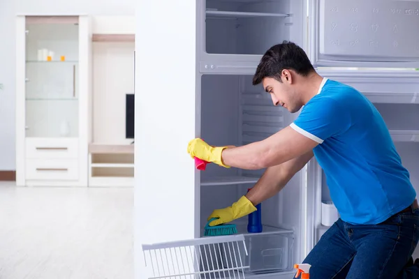 Человек чистки холодильника в концепции гигиены — стоковое фото