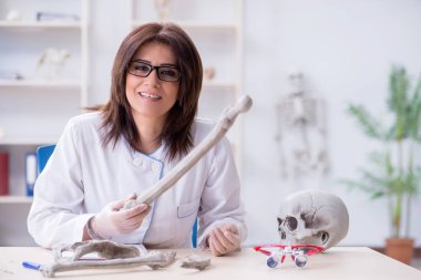 İskelet üzerinde çalışan bir doktor.