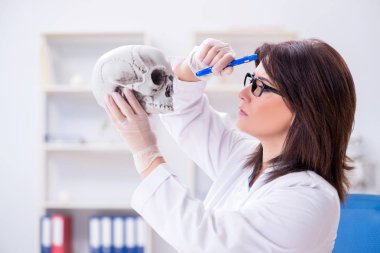 İskelet üzerinde çalışan bir doktor.