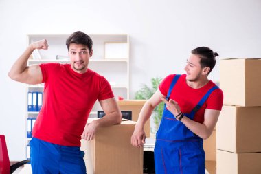 İki müteahhit personel kişisel eşyalarını taşıyor.