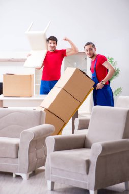 İki müteahhit personel kişisel eşyalarını taşıyor.