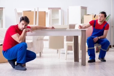 İki müteahhit personel kişisel eşyalarını taşıyor.