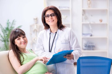 Hamile kadın düzenli kontrol için doktoru ziyaret ediyor.