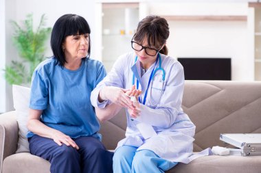 Doktor olaydan sonra yaşlı kadını muayene ediyor.