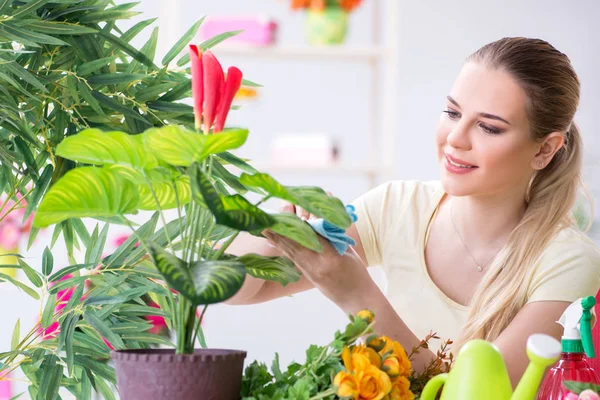 Mujer joven regando plantas en su jardín — Foto de Stock