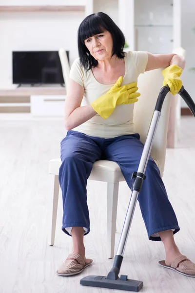 Ηλικιωμένη γυναίκα κουρασμένη μετά το καθάρισμα του σπιτιού — Φωτογραφία Αρχείου