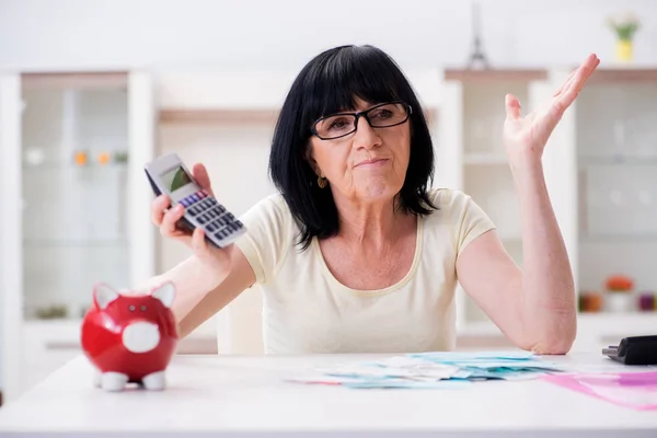 Egy érett nő próbálja összeegyeztetni a számláit. — Stock Fotó