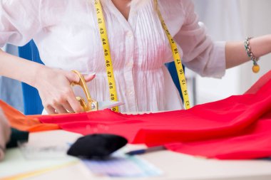 Woman tailor working on new dress designs clipart