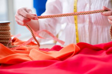 Yeni elbise tasarımları üzerinde çalışan kadın terzi.