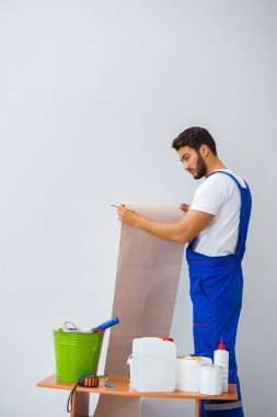 Tadilat sırasında duvar kâğıdı üzerinde çalışan işçiler