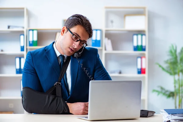 Uomo d'affari con braccio rotto che lavora in ufficio — Foto Stock