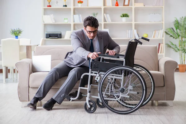 Деловой человек на инвалидной коляске работает дома — стоковое фото