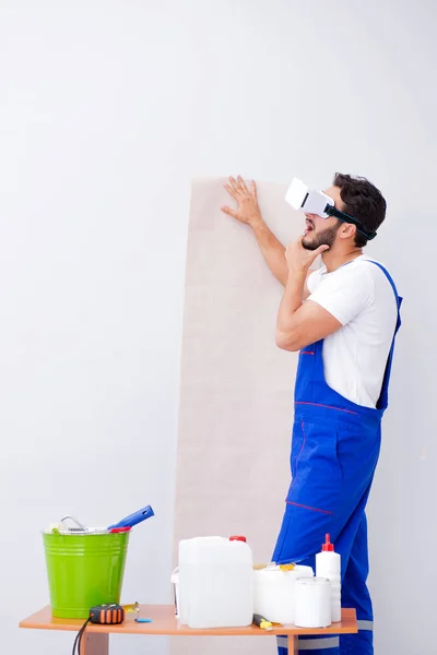 Man with VR glasses gluing wallpaper — Stock Photo, Image