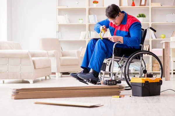 Homem com deficiência que estabelece piso laminado no escritório — Fotografia de Stock