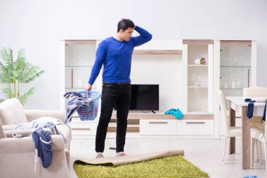 Genç adam çamaşırhane için kirli çamaşır topluyor.