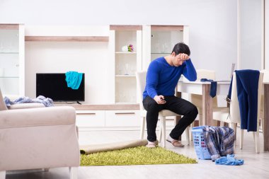 Genç adam çamaşırhane için kirli çamaşır topluyor.