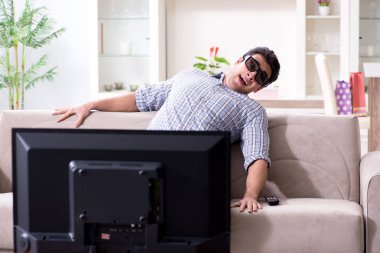 Evde 3D televizyon izleyen bir adam.