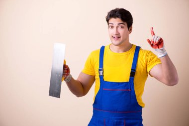 Duvara alçı yapıştıran genç müteahhit.