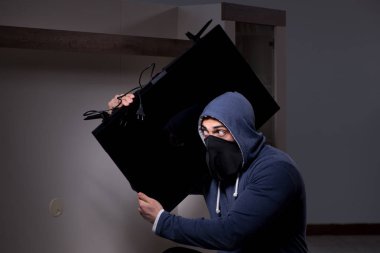 Hırsız, apartmandan televizyon çalıyor.